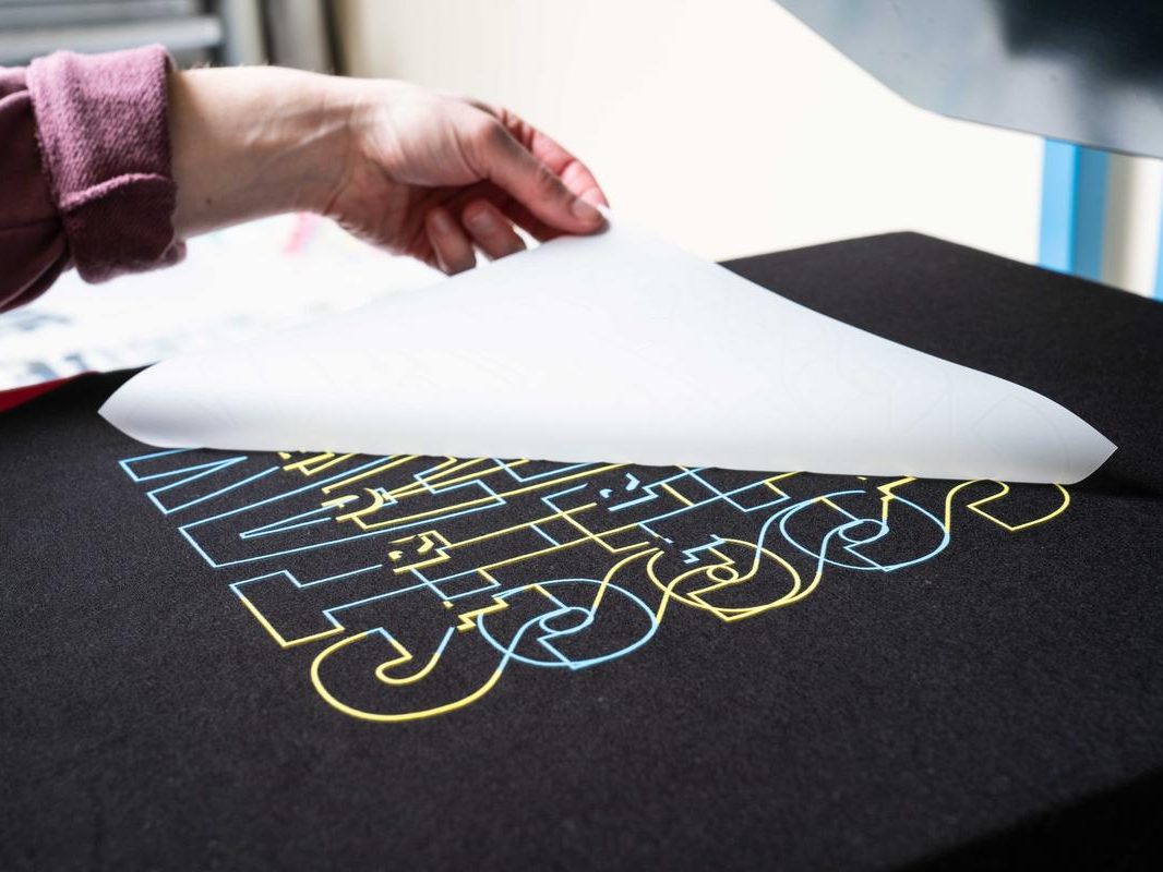 Peeling a Direct to Film transfer off a pressed shirt